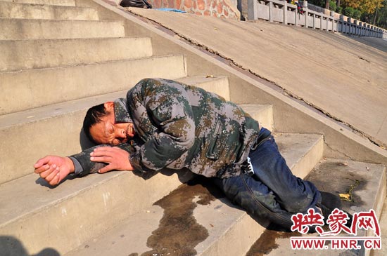 這名男子的衣服以及褲子全濕透了，水從衣褲里流出來，嘴里散發(fā)著濃烈的酒氣。