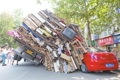 紅色小轎車被砸，卡在路邊動彈不得。