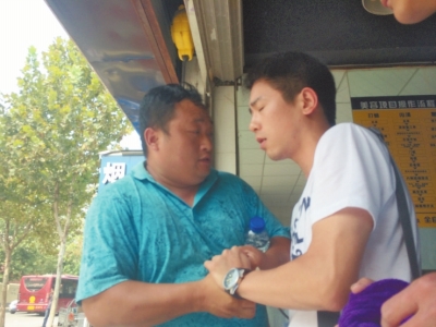 記者正查看照片，突遭藍(lán)衣男強(qiáng)搶手機(jī)。