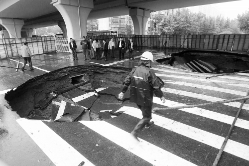 中原路西三環(huán)立交橋下由南向北原本4個車道，由于塌坑，而今3個車道被圍擋