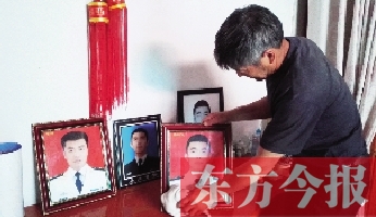 沉浸在悲痛之中的魯有海，擦拭著孩子的遺照