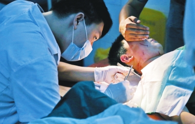 孩子身上有7道傷痕，其中兩道需要縫合，其他的均為擦傷，醫(yī)生正對(duì)他施治。