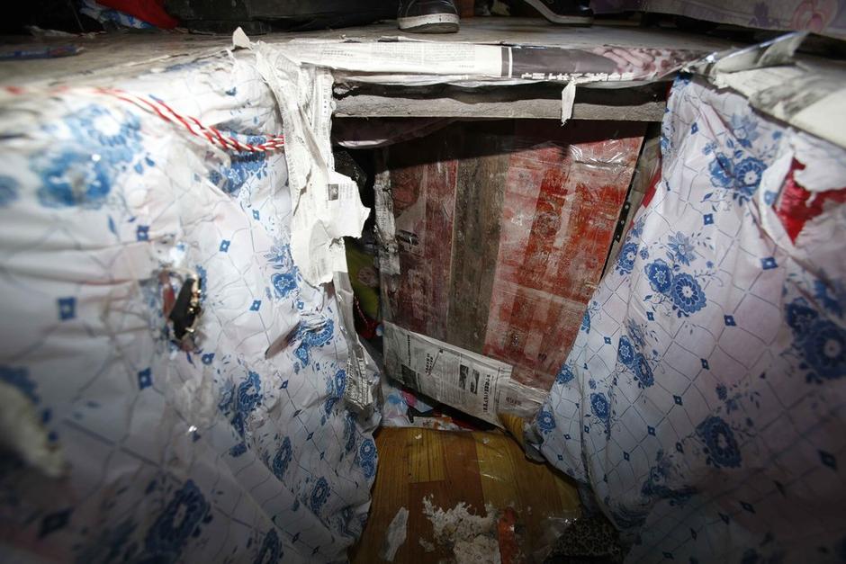 陳小龍?jiān)诔鲎馕萃猓孕杏謬鹨欢聡鷫?，安裝了一個(gè)門。圍墻上都是豎起的鐵釘，外面堆著土，鄰居猜是從地底挖出來的。洞口就在床邊，0.5米見方，深約1.5米。洞口表面一塊紙板掩蓋，打開紙板跳入洞底，是一扇小木門，木門外有插銷，可以從外面鎖上。