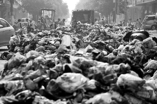 垃圾堆滿整個路口，環(huán)衛(wèi)工人們正在清理