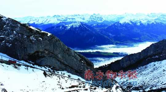  齒軌火車在皮拉圖斯山上穿行，如同紅色的龍?jiān)谏街杏芜? complete=