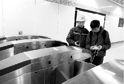 昨天上午，體育中心站，工作人員正在對進出站閘機進行調(diào)試。