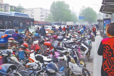 省人民醫(yī)院北門，路邊的公交站牌處停滿非機(jī)動(dòng)車，上、下客只能在快車道上。