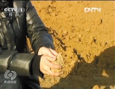 麻剛沙系麻剛石粉碎而成。記者找到一塊麻剛石，一捏就碎成粉末，硬度非常差。央視截圖