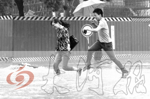 鄭州經(jīng)三路與北環(huán)交叉口處，積水較深，行人們不得不“練輕功”。 記者 白周峰 攝影