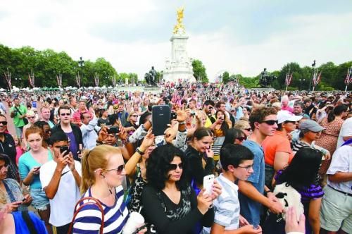 7月23日，在英國倫敦白金漢宮外，民眾們爭相閱讀“王室寶寶”出生的正式公告。