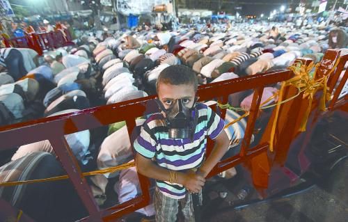 當(dāng)?shù)貢r(shí)間28日晚，在埃及開(kāi)羅納賽爾城，一名小男孩頭戴防毒面具參加穆兄會(huì)的集會(huì)示威。