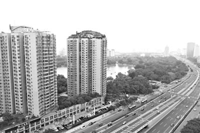 昨日，人濟(jì)山莊小區(qū)，與其他樓相比，B棟樓頂層天臺上違規(guī)建造了一棟兩層小樓，假山大樹俱全。新京報(bào)記者