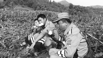 饑餓難忍，中國(guó)緊急救援河南基地的救援隊(duì)員在已毀的玉米地里撿拾生玉米吃。