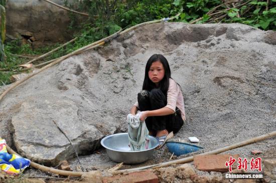 8月9日，云南巧家紅石巖村，10歲的劉鑫蕊在洗自己的衣服
