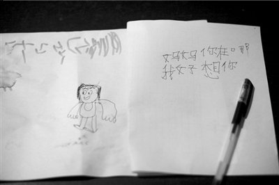 名叫袁明燕的小姑娘用筆在紙上不斷寫“媽媽”二字。