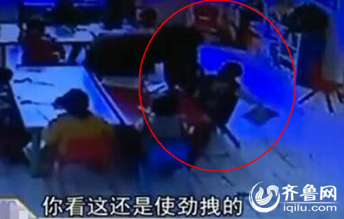 孩子上課時(shí)被老師拖拽。（紅圈中拿書者系孩子）