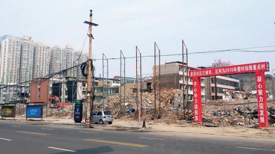 015年5月31日，在社區(qū)干部的帶頭拆遷下，親賢社區(qū)的“城中村改造”拉開(kāi)帷幕。由于前期“清產(chǎn)核資”及補(bǔ)償標(biāo)準(zhǔn)等因素，拆遷改造工作推進(jìn)并不順利。圖為位于體育西路東側(cè)集體所有的商鋪率先被拆遷完畢，用于遮擋的圍擋正在施工中。（拍攝：2015年9月16日）