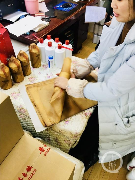 正在對(duì)白酒進(jìn)行包裝處理的經(jīng)營(yíng)戶。