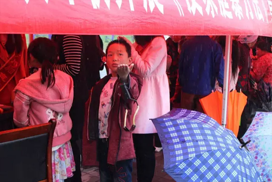 因?yàn)橛晗碌奶?，小男孩玩起了接水游戲? oldsrc=