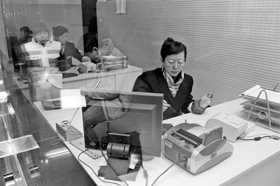 2月16日，鄭州市自來水總公司鄭東新區(qū)一營業(yè)廳，柜臺內(nèi)工作人員正在為市民辦理業(yè)務