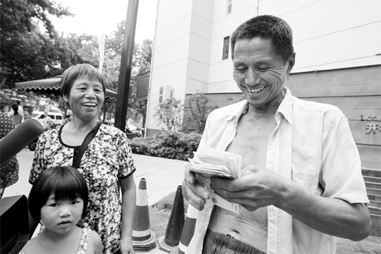 昨日，鄭州市明達(dá)路與豐慶路交叉口西300米路南，來(lái)自中牟的瓜農(nóng)拿到西瓜款，笑開(kāi)顏東方今報(bào)記者袁曉強(qiáng)