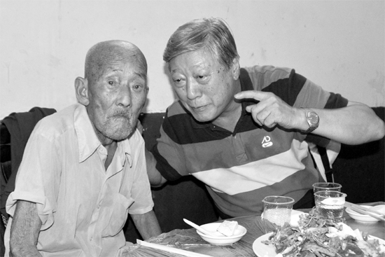 昨日，來自北京的英雄后代胡冠軍（右）專門趕到西平縣看望抗戰(zhàn)老兵孫殿修老人