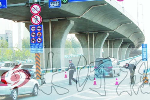 交警在東風路從北向南上橋口處擺上反光錐，間歇放行