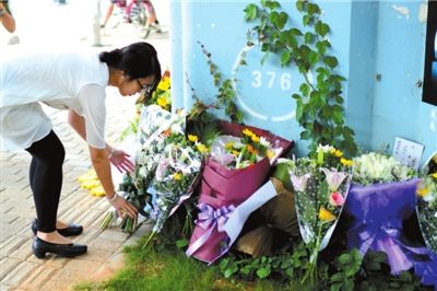 6月8日下午，記者來到廈門公交車爆炸事發(fā)現(xiàn)場橋下，附近已聚集了十幾個自發(fā)前來悼念的市民。橋墩下排放了一圈或黃或白的菊花，還有玖瑰、百合等。