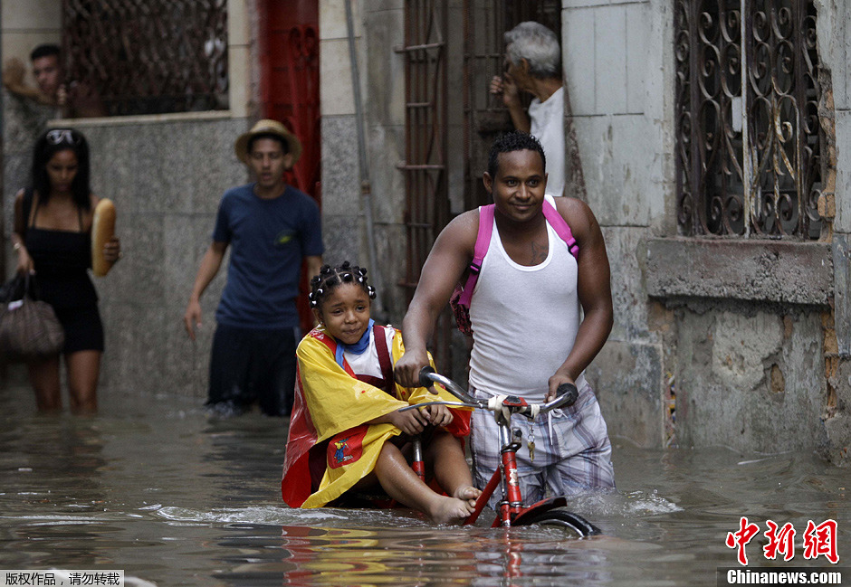 圖為哈瓦那民眾冒水出行。