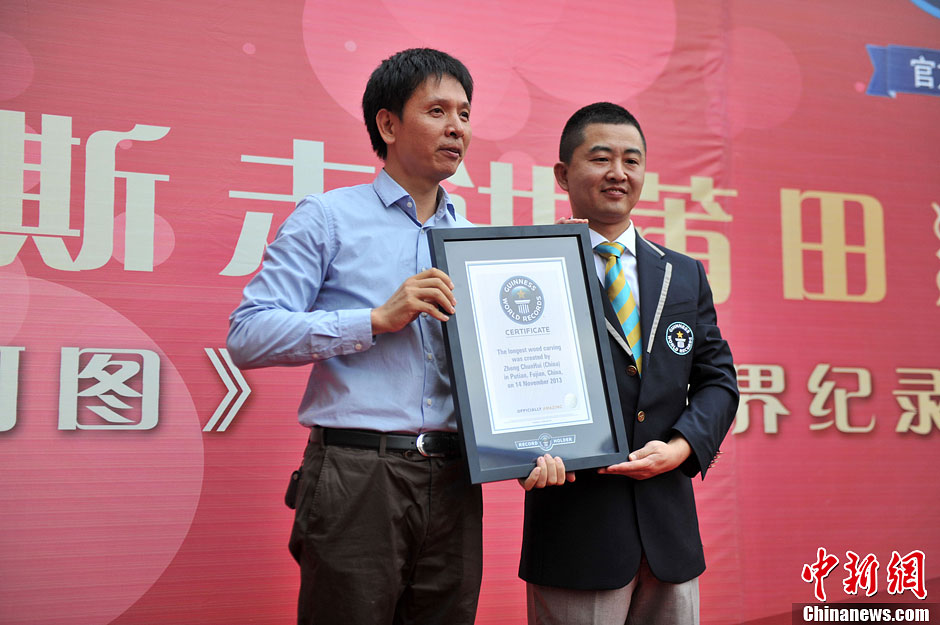 圖為世界吉尼斯認(rèn)證官為鄭春輝（左）頒發(fā)證書。呂明 攝