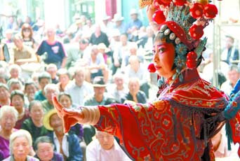 圖為8月15日戲曲演員在“流動(dòng)舞臺(tái)車”上表演傳統(tǒng)地方戲《穆桂英下山》。