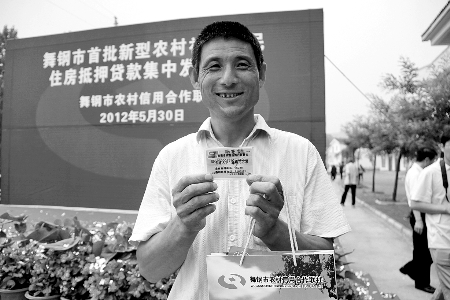 領(lǐng)到貸款，農(nóng)民開心地笑了。