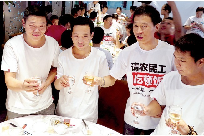 活動發(fā)起人張楠（右二）給農民工敬酒。