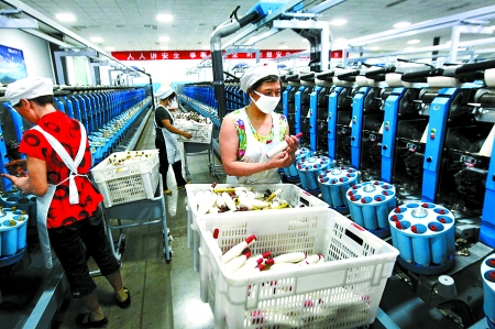 6月6日，舞鋼市鑫海紡織有限公司員工正在新建成的紡紗車間生產(chǎn)。