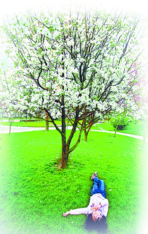 　孩子愜意地躺在社區(qū)內(nèi)的草坪上。