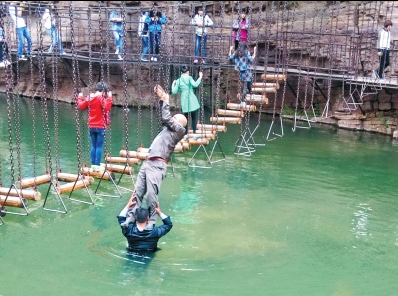 中年男游客正踩著景區(qū)安全員郭小明的肩膀過河。網(wǎng)友“@我的小名叫張孩”供圖