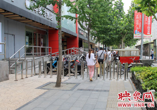 圖中道路左側(cè)的無(wú)障礙通道被鋼管隔離,右側(cè)的盲道也被侵占。