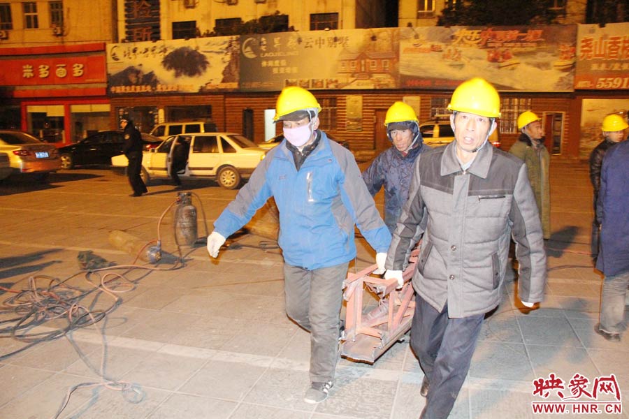 23點(diǎn)56分，第一塊兒廣告牌已經(jīng)分割完畢，地面上的20多名工人將拆除下來的鋼件撞車運(yùn)走。