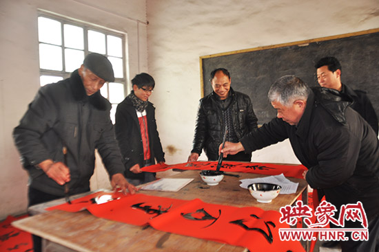 鞏義市魯莊鎮(zhèn)農(nóng)民書法愛好者正在寫春聯(lián)。