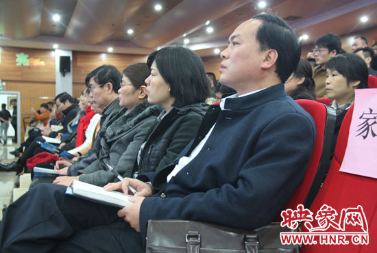 認真聽取招生政策的學(xué)生家長。