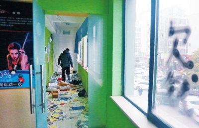 　健身會所地上一片狼藉，玻璃上噴著黑色“欠錢”二字。