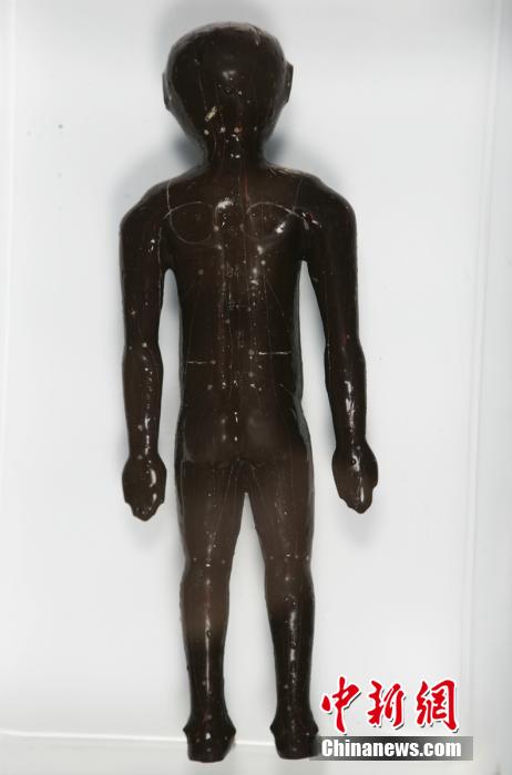 圖為出土的人體經(jīng)穴漆俑。