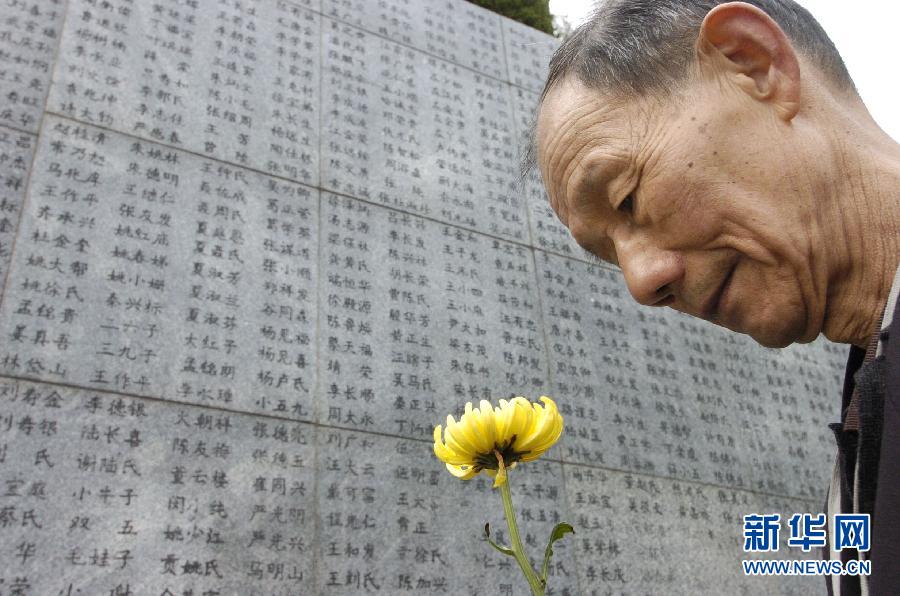 2006年4月5日，74歲的南京大屠殺幸存者佘子清手捧鮮花，祭奠被日軍殺害的母親。