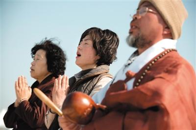 23日，一名僧侶引領(lǐng)人們?yōu)樗勒咂矶\。