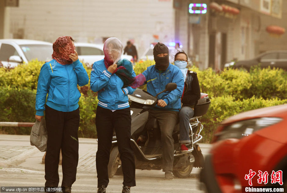 2014年04月23日，新疆維吾爾自治區(qū)吐魯番地區(qū)，市民戴著口罩行走在大風(fēng)沙塵中的吐魯番市街頭。