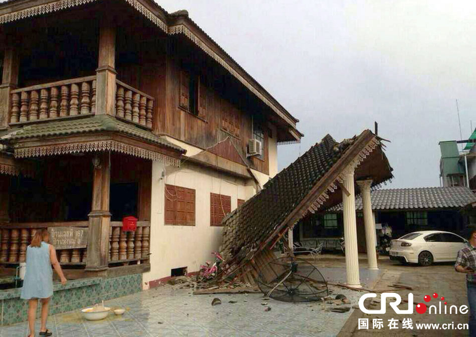 當(dāng)?shù)貢r間2014年5月5日，泰國清萊，一名婦女看著受損的房屋。 圖片來源：東方IC