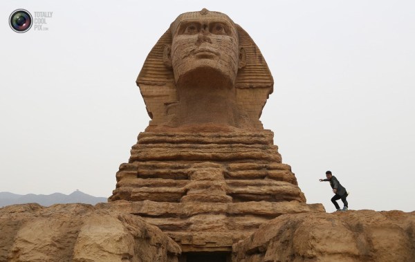 石家莊郊外，一名男子與山寨版獅身人面像合影留念。