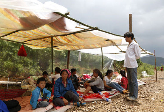 暴雨馬上來臨，村民們在簡易帳篷下躲雨。澎湃新聞 程藝輝 圖