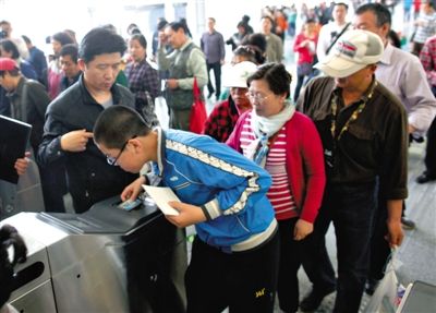 去年5月5日，14號線園博園站，乘客刷卡出地鐵。北京公交地鐵將實(shí)行計(jì)程票制，多乘坐多付費(fèi)。