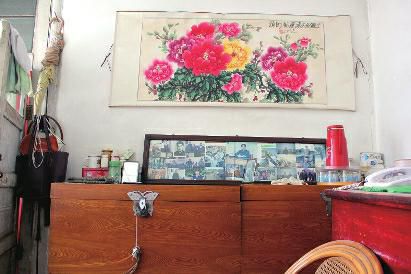 　陳會英將兒女的照片都裱起來，裝在一個大相框里，放在箱子上經(jīng)?？矗渲凶疃嗟木褪莿⒔饑恼掌?。